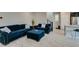 Cozy living room featuring plush blue seating, seamlessly connecting to the kitchen area at 3192 Bormida Ave, Henderson, NV 89044