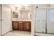 Bathroom featuring dual sinks, wooden cabinetry, and a glass-enclosed shower, offering functionality at 3411 Holly Ave, Las Vegas, NV 89106