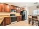 Traditional-style kitchen featuring brown wooden cabinetry, granite countertops, and modern appliances at 3411 Holly Ave, Las Vegas, NV 89106