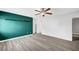 Large primary bedroom with laminated floor, green accent wall and modern ceiling fan at 3449 Lorilou Ln # 2, Las Vegas, NV 89121