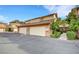 Home exterior featuring a two-car garage, a brick facade, and mature landscaping at 3449 Lorilou Ln # 2, Las Vegas, NV 89121