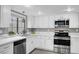 Bright kitchen with stainless appliances, white cabinets, and ample counter space by the window at 3449 Lorilou Ln # 2, Las Vegas, NV 89121