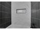 The modern bathroom features white and gray tiles, a built-in shower niche and modern fixtures at 3484 Nightflower Ln # B, Las Vegas, NV 89121