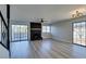 Open living room boasts a black fireplace, modern lighting, wood-look flooring, and expansive sliding doors at 3484 Nightflower Ln # B, Las Vegas, NV 89121
