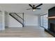 Spacious living room featuring a black fireplace, wood-look floors, black ceiling fan and staircase at 3484 Nightflower Ln # B, Las Vegas, NV 89121