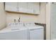 Bright laundry room with a modern, stacked washer and dryer and ample upper cabinet storage space for convenience at 3665 Bronco Rd, Las Vegas, NV 89103