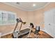 A home gym space featuring tile floors, essential workout equipment, and natural light at 3724 Thomas Patrick Ave, North Las Vegas, NV 89032