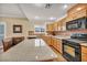 A bright kitchen featuring granite countertops, stainless steel appliances, and wooden cabinets at 3724 Thomas Patrick Ave, North Las Vegas, NV 89032