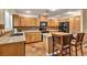 A well-lit kitchen featuring tile floors, wooden cabinets, and a cozy island seating area at 3724 Thomas Patrick Ave, North Las Vegas, NV 89032