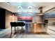 Modern kitchen features a stainless steel island with bar seating and contemporary pendant lighting at 4381 W Flamingo Rd # 2322/2320, Las Vegas, NV 89103