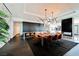 Modern dining area with unique chandelier, marble wall, open kitchen, and black hardwood floors at 4381 W Flamingo Rd # 5708, Las Vegas, NV 89103