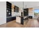 Modern kitchen features a breakfast bar, marble backsplash, and sleek black cabinetry at 500 Trenier Dr, Henderson, NV 89002