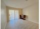 Empty living room featuring wood-look tile flooring, sliding door to patio, and accent table at 5171 Lindell Rd # 107, Las Vegas, NV 89118