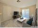 Living room with a neutral color palette, featuring a sliding glass door, modern TV, and sleek marble coffee table at 5171 Lindell Rd # 107, Las Vegas, NV 89118