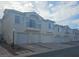 Townhouse exterior featuring garages and small balconies on a sunny day with light cloud cover at 6201 E Lake Mead Blvd # 156, Las Vegas, NV 89156