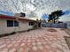 Spacious backyard featuring a patterned tile patio, a built-in fire pit, and mature landscaping at 6216 Bullion Blvd, Las Vegas, NV 89103