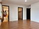 Spacious bedroom featuring wood-look floors, white walls and dark doors leading to bathroom and closet at 6216 Bullion Blvd, Las Vegas, NV 89103