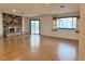 Spacious living room featuring wood-look floors, a brick fireplace and natural light at 6216 Bullion Blvd, Las Vegas, NV 89103