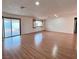 Spacious living room featuring wood-look floors and a sliding glass door to backyard at 6216 Bullion Blvd, Las Vegas, NV 89103