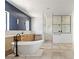 Bright bathroom featuring a blue tiled wall, soaking tub, dual sinks and a glass enclosed shower at 6383 Horse Dr, Las Vegas, NV 89131