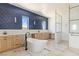 Bright bathroom featuring a blue tiled wall, soaking tub, dual sinks and a glass enclosed shower at 6383 Horse Dr, Las Vegas, NV 89131