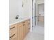 Beautiful bathroom boasts a wood vanity with black hardware, complemented by a white countertop, and patterned floor tiling at 6383 Horse Dr, Las Vegas, NV 89131