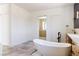 Bright bathroom featuring a soaking tub, dual sinks and a walk-in closet at 6383 Horse Dr, Las Vegas, NV 89131