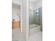 Contemporary bathroom featuring a tub, a frameless glass shower door, and a light wood vanity in the adjacent room at 6383 Horse Dr, Las Vegas, NV 89131