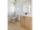 Modern bathroom with a wood vanity, sleek mirror, and a single window at 6383 Horse Dr, Las Vegas, NV 89131