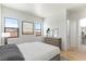 Bright bedroom with white walls, art decor, wood floors and natural light from three windows at 6383 Horse Dr, Las Vegas, NV 89131