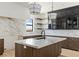 Stylish kitchen featuring stainless steel sink, marble countertops/backsplash, and custom wood-toned cabinets at 6383 Horse Dr, Las Vegas, NV 89131
