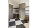 Contemporary laundry room boasts black and white tile floor, ample custom cabinetry, and lots of storage at 6383 Horse Dr, Las Vegas, NV 89131