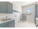 Spacious laundry room with sink, cabinetry, shower, and natural light at 6383 Horse Dr, Las Vegas, NV 89131