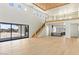 Spacious open-concept living room with high ceilings, light hardwood floors, and a staircase leading to the second floor at 6383 Horse Dr, Las Vegas, NV 89131