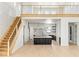 Spacious living room with view of the kitchen, featuring staircase with black iron railing, and high ceilings at 6383 Horse Dr, Las Vegas, NV 89131