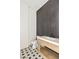 Chic powder room featuring a wood vanity with a sleek white countertop and a bold black-tiled accent wall at 6383 Horse Dr, Las Vegas, NV 89131