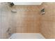 Detailed view of a bathtub with decorative tile surround, a shower head, and toiletry dispensers for a spa-like experience at 6408 Starcrest Dr, Las Vegas, NV 89108