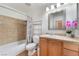 Cozy bathroom with vanity, decorative mirror, and a combined shower and bathtub with patterned shower curtain at 6408 Starcrest Dr, Las Vegas, NV 89108
