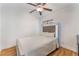 Cozy bedroom with a tufted headboard, ceiling fan, and minimalist decor, offering a comfortable and relaxing ambiance at 6408 Starcrest Dr, Las Vegas, NV 89108