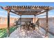 Outdoor seating and dining area under the pergola next to the pool at 6408 Starcrest Dr, Las Vegas, NV 89108