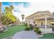 Exterior view of the backyard with synthetic lawn, mature plants, and a covered patio at 788 Rossmore Dr, Las Vegas, NV 89110