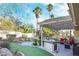 Backyard features an outdoor kitchen, artificial turf, patio, landscaping, and mature trees at 788 Rossmore Dr, Las Vegas, NV 89110