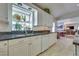 Well-lit kitchen with granite countertops, white cabinetry, and a garden window with plants at 788 Rossmore Dr, Las Vegas, NV 89110