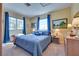 Bedroom featuring a large window, blue curtains, and matching bedding at 788 Rossmore Dr, Las Vegas, NV 89110