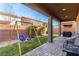 Covered back patio with desert landscaping and a playset at 7884 Patagonia Point Ct, Las Vegas, NV 89179