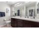 Elegant bathroom features dual sinks, a large mirror, a separate toilet area, and a shower-tub combo at 7884 Patagonia Point Ct, Las Vegas, NV 89179