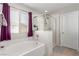Bright bathroom with a separate tub and a glass-enclosed shower, next to a sunny window at 7884 Patagonia Point Ct, Las Vegas, NV 89179