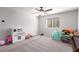 Spacious bedroom with plush carpet, a ceiling fan and a sunlit window at 7884 Patagonia Point Ct, Las Vegas, NV 89179