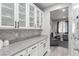 Lovely butler pantry featuring granite countertops, tiled backsplash, and glass-front cabinetry at 7884 Patagonia Point Ct, Las Vegas, NV 89179