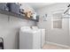 Well-lit laundry room featuring modern washer and dryer units, shelving, and storage solutions for organization at 7884 Patagonia Point Ct, Las Vegas, NV 89179